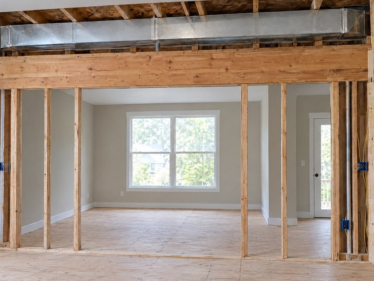 Illustration: living room east wall open, with the duct run above the header