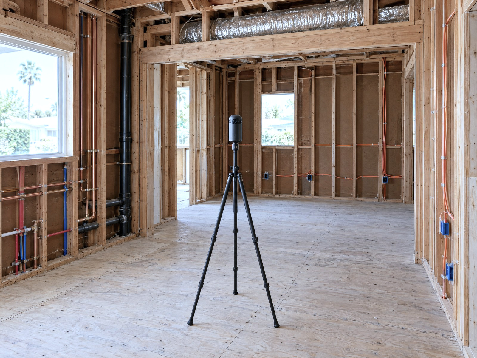 Illustration: a LiDAR scanner on its tripod in a house with the walls open to the studs